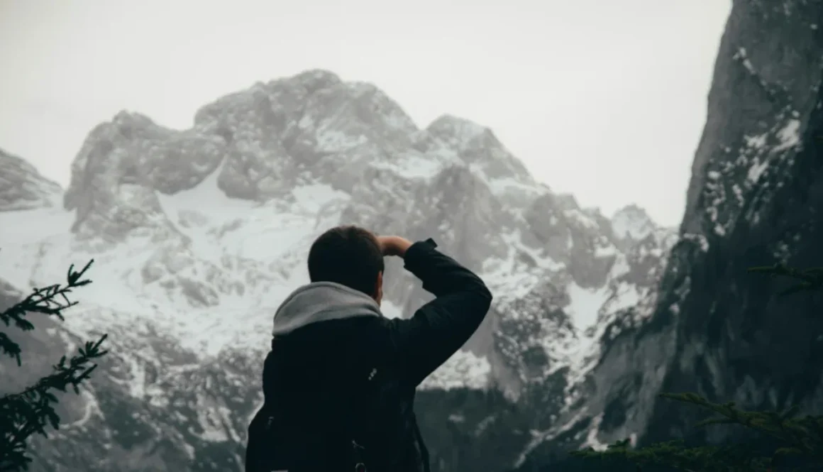 A lone man staring at a mountain peak- Symbolizing the relentless pursuit of impossible goals.
