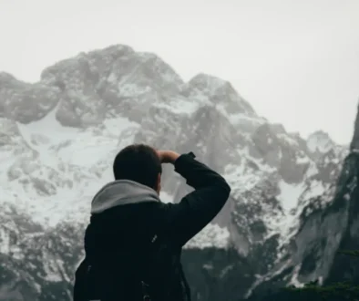 A lone man staring at a mountain peak- Symbolizing the relentless pursuit of impossible goals.