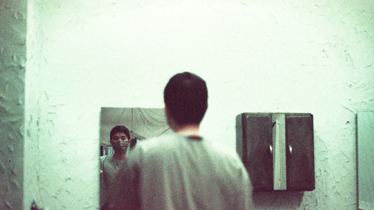 A man looking himself in the mirror & making a conversation, which will help him boost confidence.