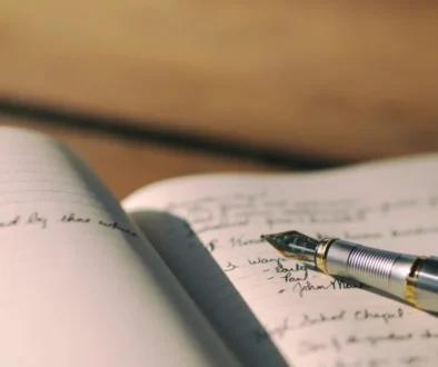 A fountain pen resting on an open journal with handwritten notes, symbolizing the reflective practice of Stoic journaling.