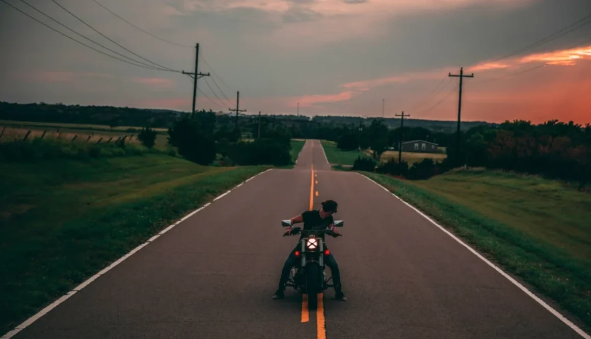 A man sitting on a motorbike, looking back over his shoulder, symbolizing reflection and acceptance of life’s journey — embodying the Stoic idea of Amor Fati.